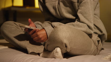 woman using smartphone in bed