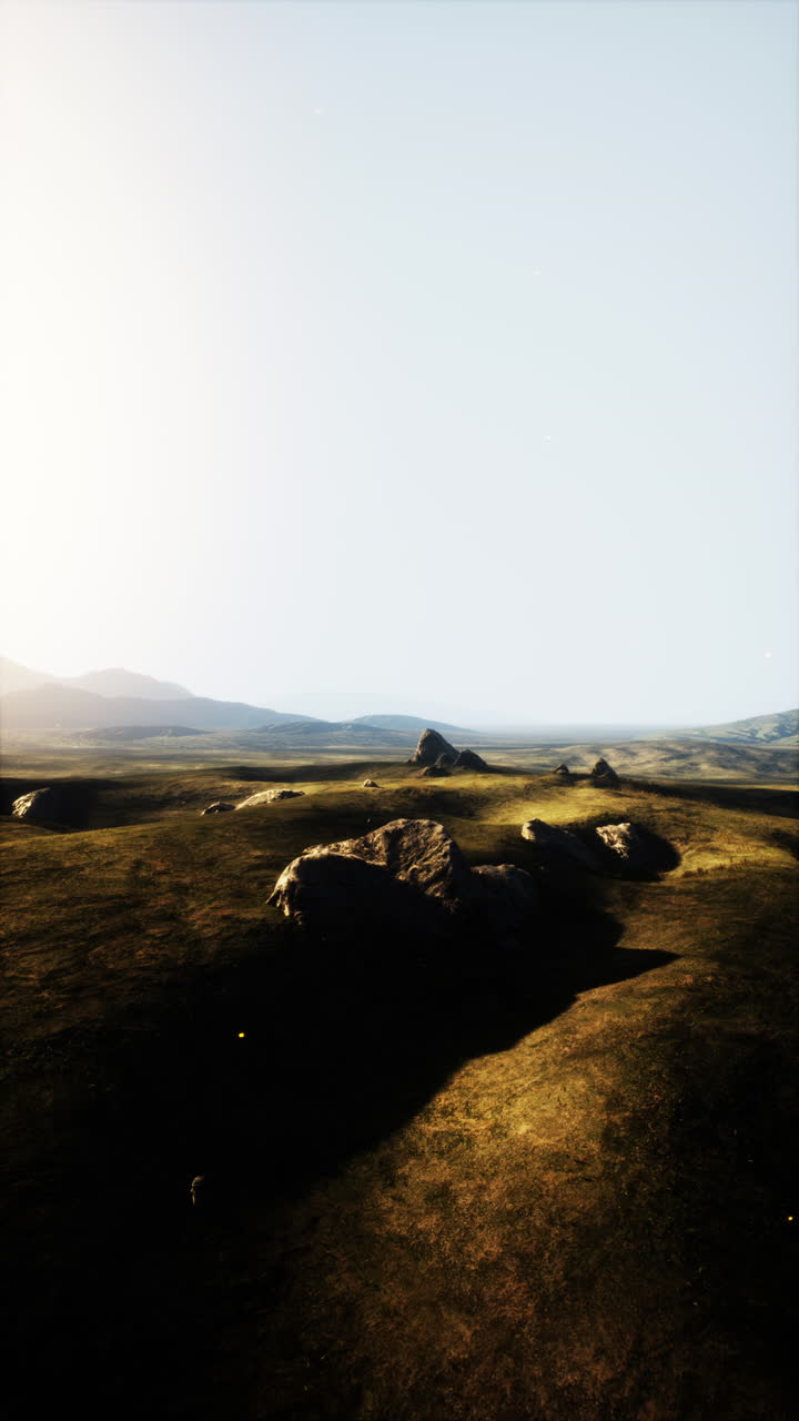 campo de hierba con rocas y colinas