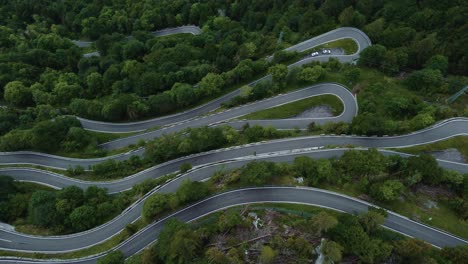 Círculo-Volador-En-La-Idílica-Carretera-Serpentina-De-Montaña-Plöckenpass-En-Los-Alpes-Austriacos-E-Italianos-Naturales-En-Verano-Con-árboles-Verdes-Y-Coches-En-La-Calle