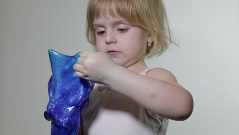 child having fun making slime. kid playing with hand made toy slime.