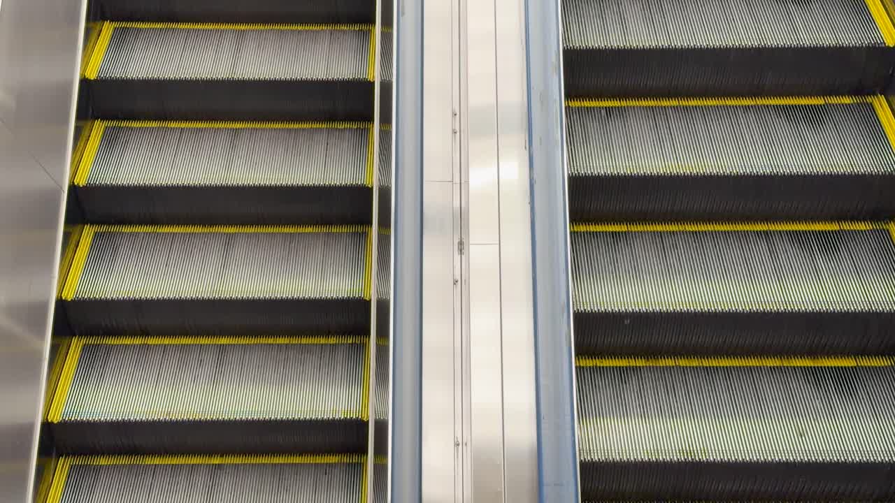 Et statisk højvinkelbillede fanger den rytmiske bevægelse af tomme rulletrappestrin i Tokyo.
