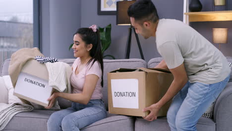 a young couple happily putting away clothing to be