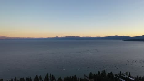 peaceful water of lake tahoe with sailing charter boats during sunset in california, united states