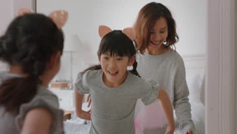 asian mother and daughter playing dress up game at home little girl having fun with mom enjoying playful day with child together on weekend happy family 4k footage