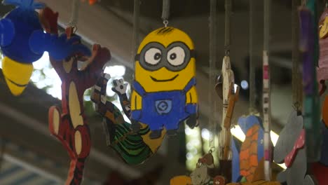 La-Figura-De-Un-Minion-De-Madera-Cuelga-Del-Techo-Entre-Otras-Figuras