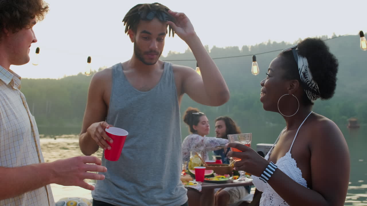 호수 파티에서 대화하는 다양한 긍정적인 친구들