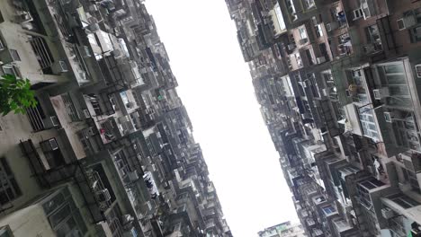 looking up at the towering residential buildings in quarry bay, hong kong. the dense architecture creates a unique urban landscape, showcasing high-rise living.