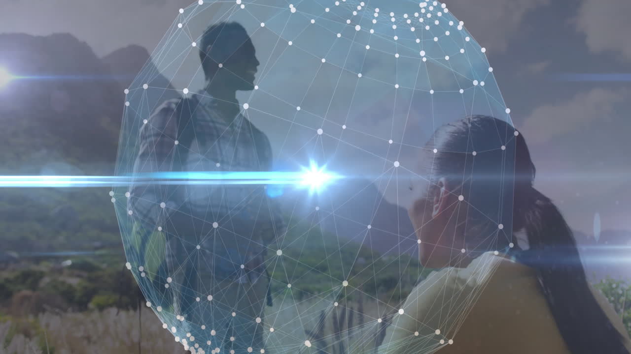 man with backpack standing and woman crouching on hill, featuring tech network sphere overlay