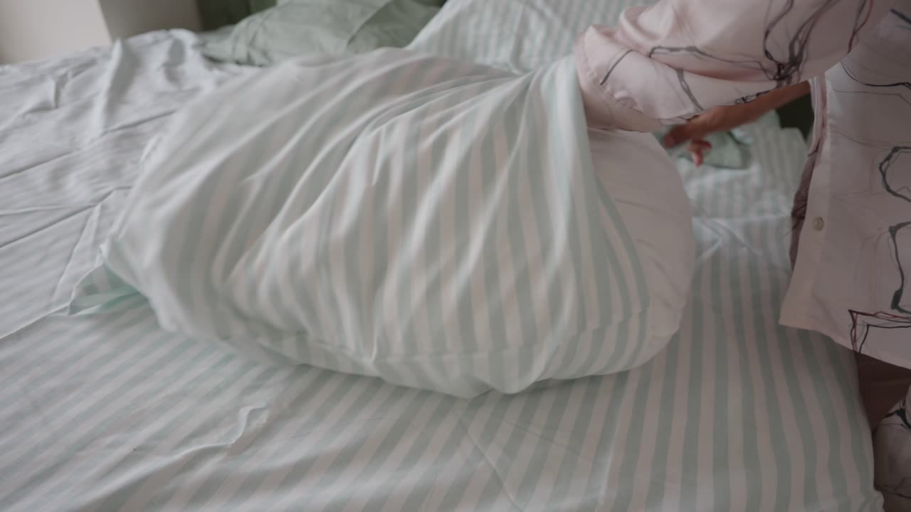 Making a bed with striped sheets