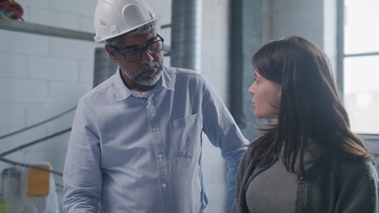 Senior Architect and Designer Discussing House Sketch on Construction Site