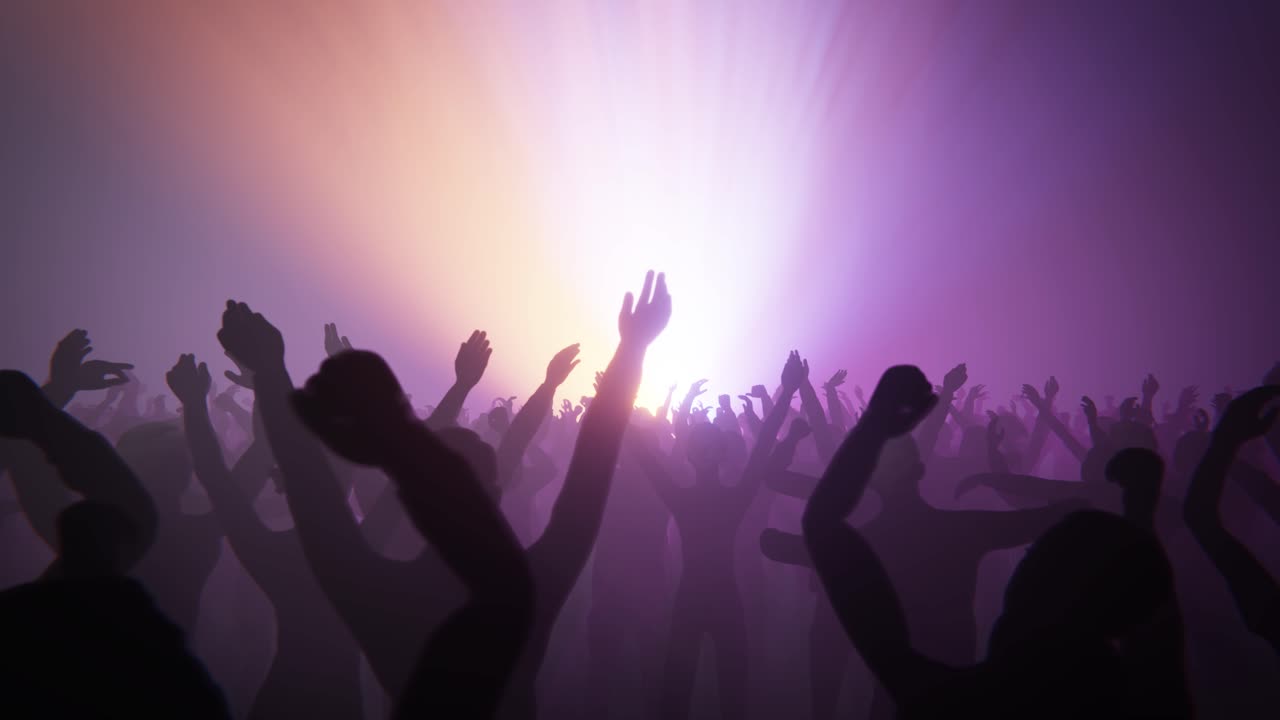 Folla in silhouette che esulta e agita le mani a un concerto vibrante