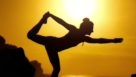 mujer practicando yoga al atardecer