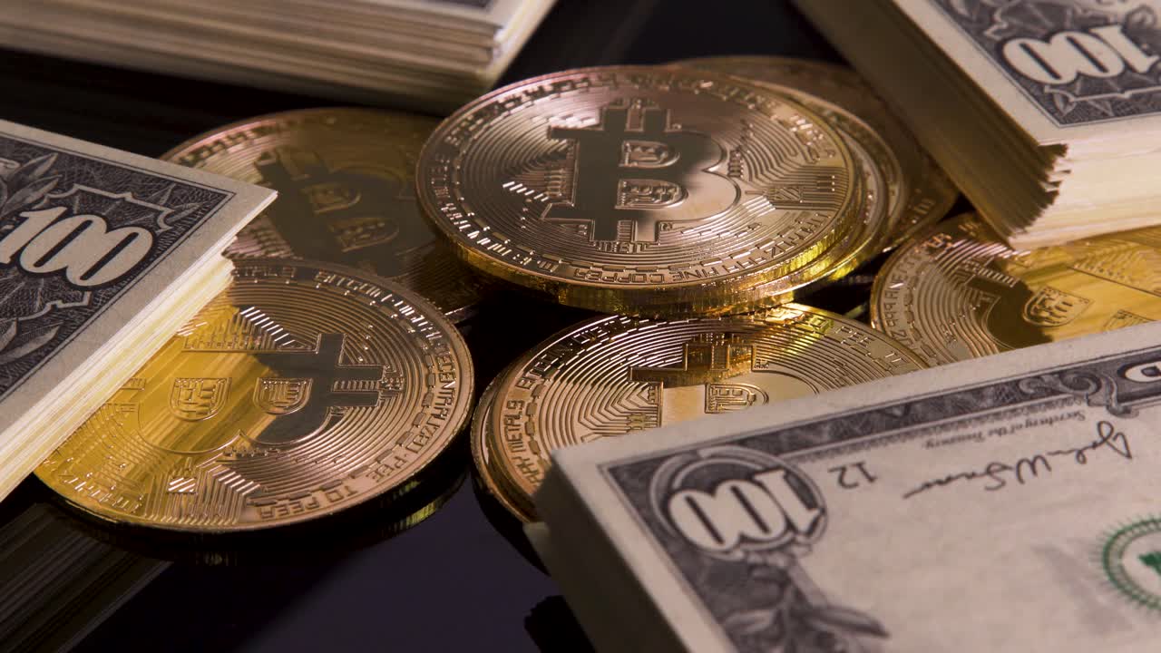 Golden bitcoins with stacks of hundred dollar bills turning on reflective black glass background, cryptocurrency investment profits