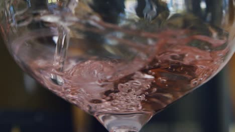 Zeitlupen-Rosé-Wird-In-Ein-Glas-Gegossen,-Wobei-Viele-Oxidierte-Blasen-Entstehen