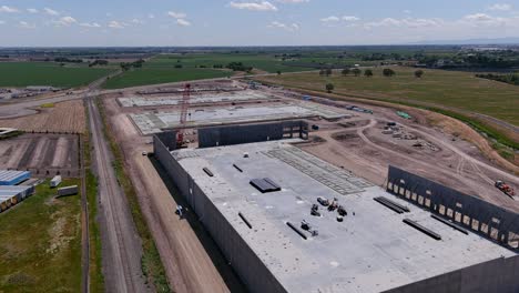 A-descending-shot-of-a-crane-setting-a-wall-in-a-commercial-building