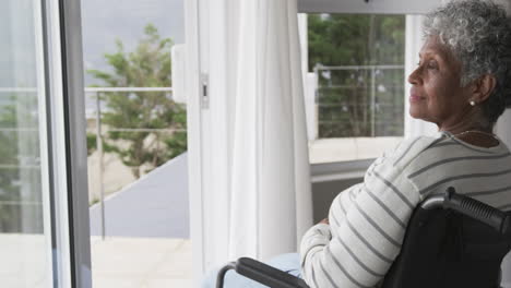 senior african american woman in wheelchair by window, copy space, slow motion