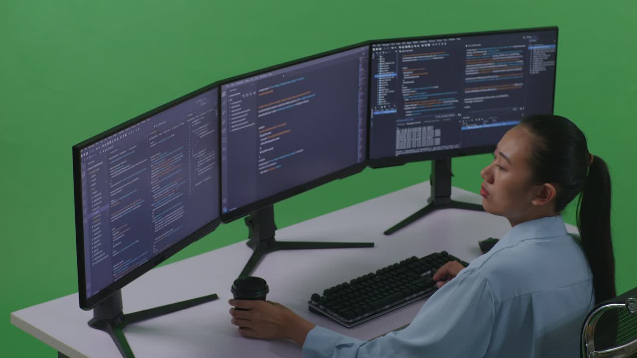 mujer programadora trabajando en múltiples pantallas