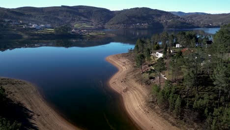 Toma-Aérea-De-Una-Plataforma-Rodante-De-Una-Playa-De-Arena-A-Orillas-Del-Río-A-Lo-Largo-De-La-Laguna-Del-Parque-Nacional-Peneda-Gerês