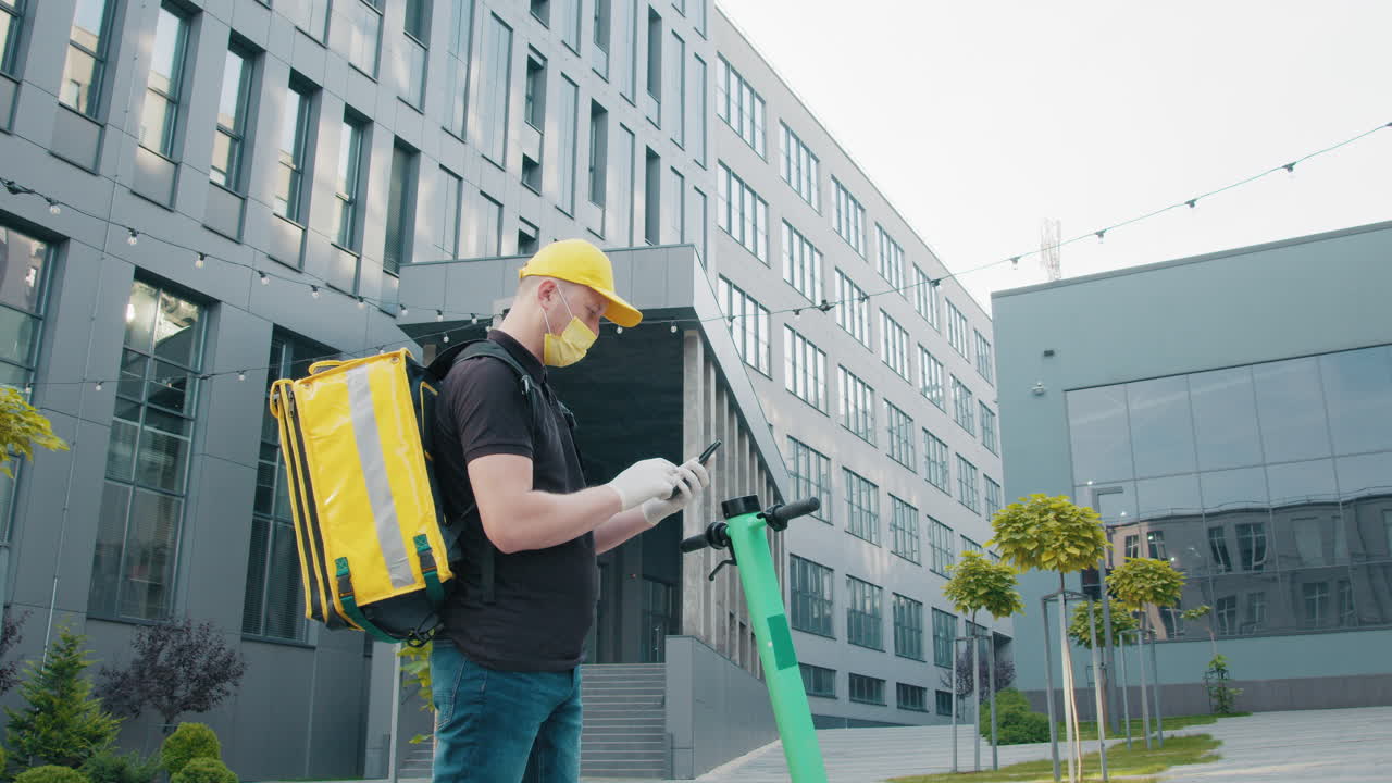 Corriere con smartphone su scooter elettrico