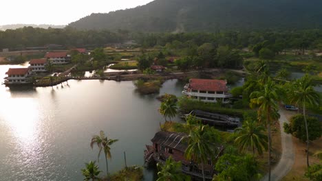 abandoned resort showing decaying buildings, surrounded by palm trees and a lake, in koh chang, thailand. stunning aerial view flight panorama overview drone