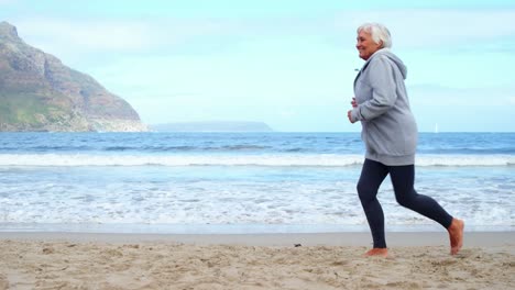 senior woman jogging on the beach