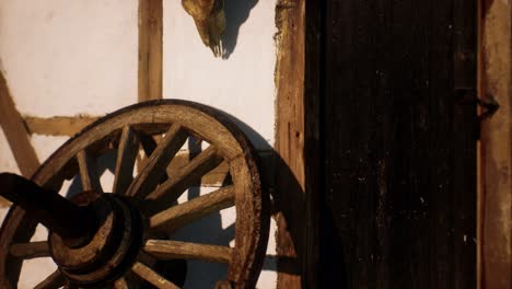 old wood wheel and black door at white house