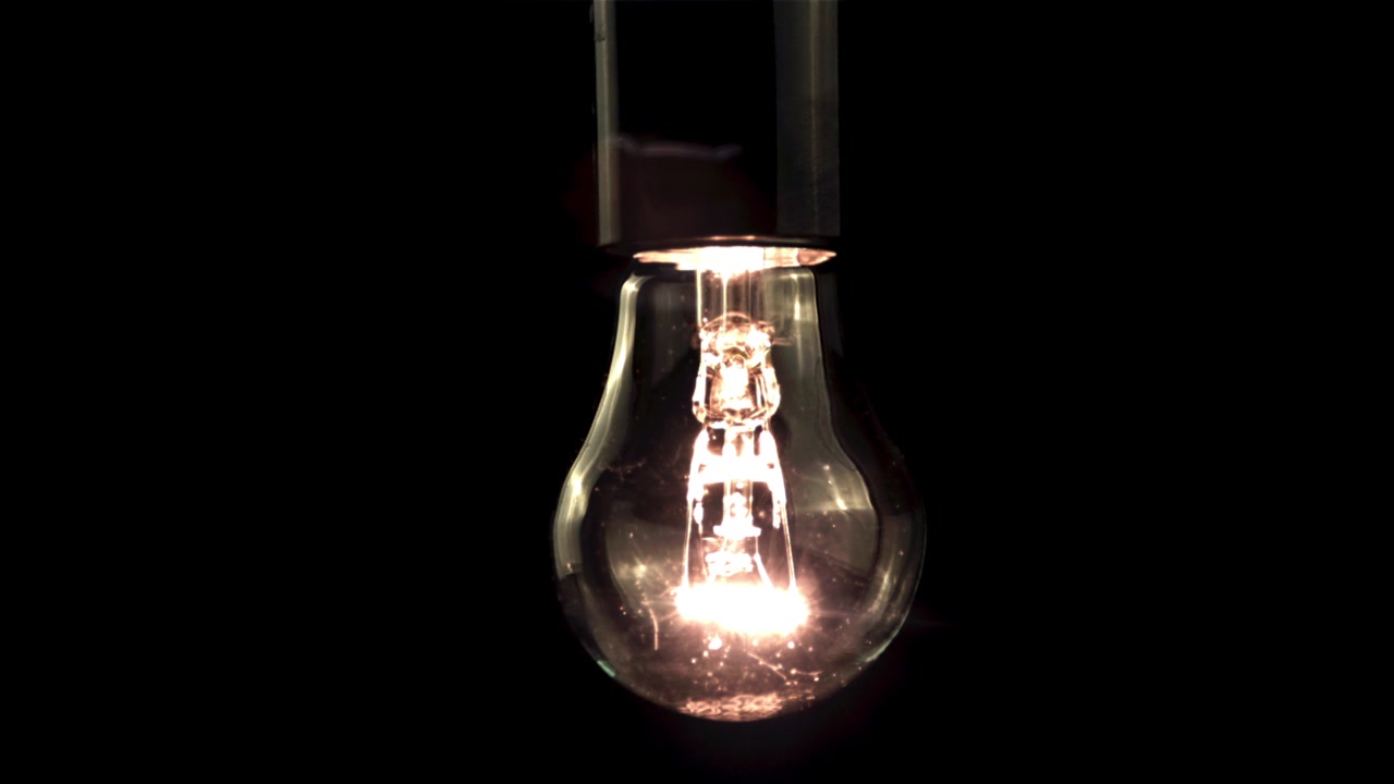 Bombilla Incandescente Iluminándose Lentamente en la Oscuridad
