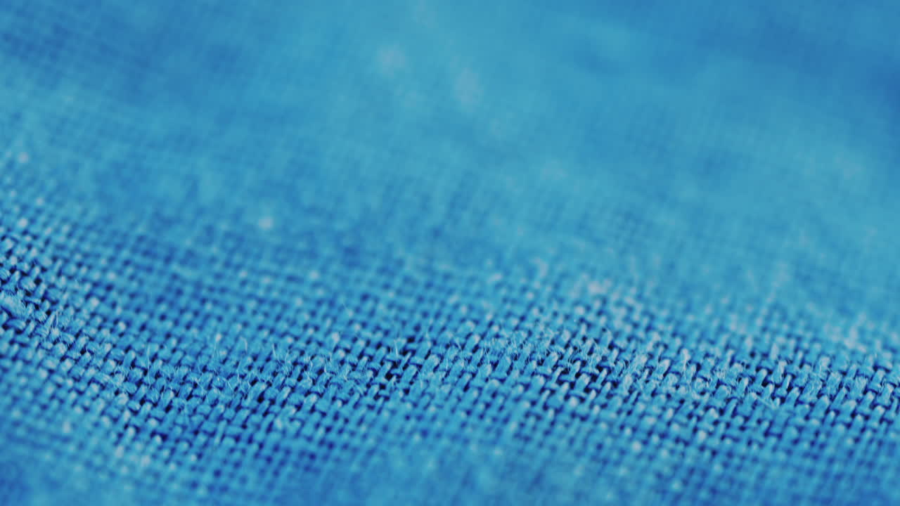 Close up of blue denim fabric texture showing fine threads and detailed textile pattern