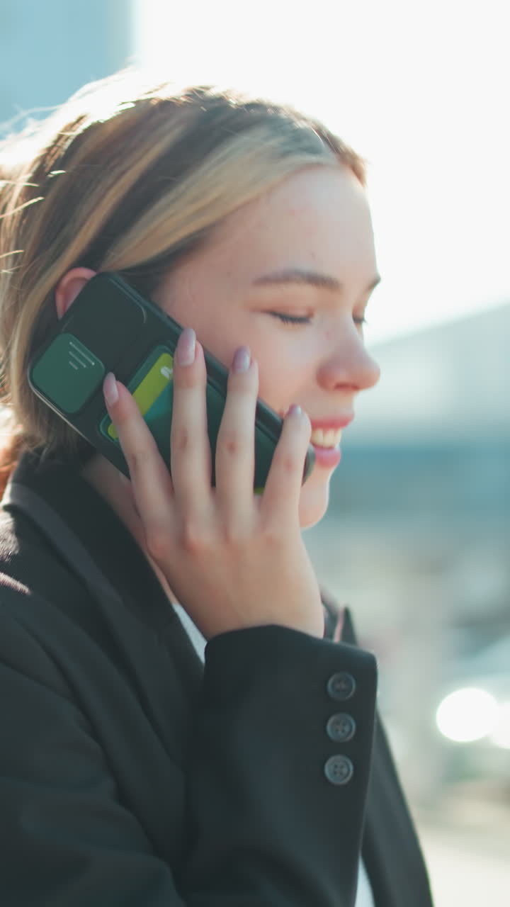 Close up rear view of lecturer in professional attire walking with handbag on arm, background blurred showing passing cars and urban setting