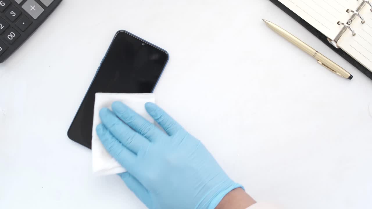 limpieza de un teléfono inteligente con guantes