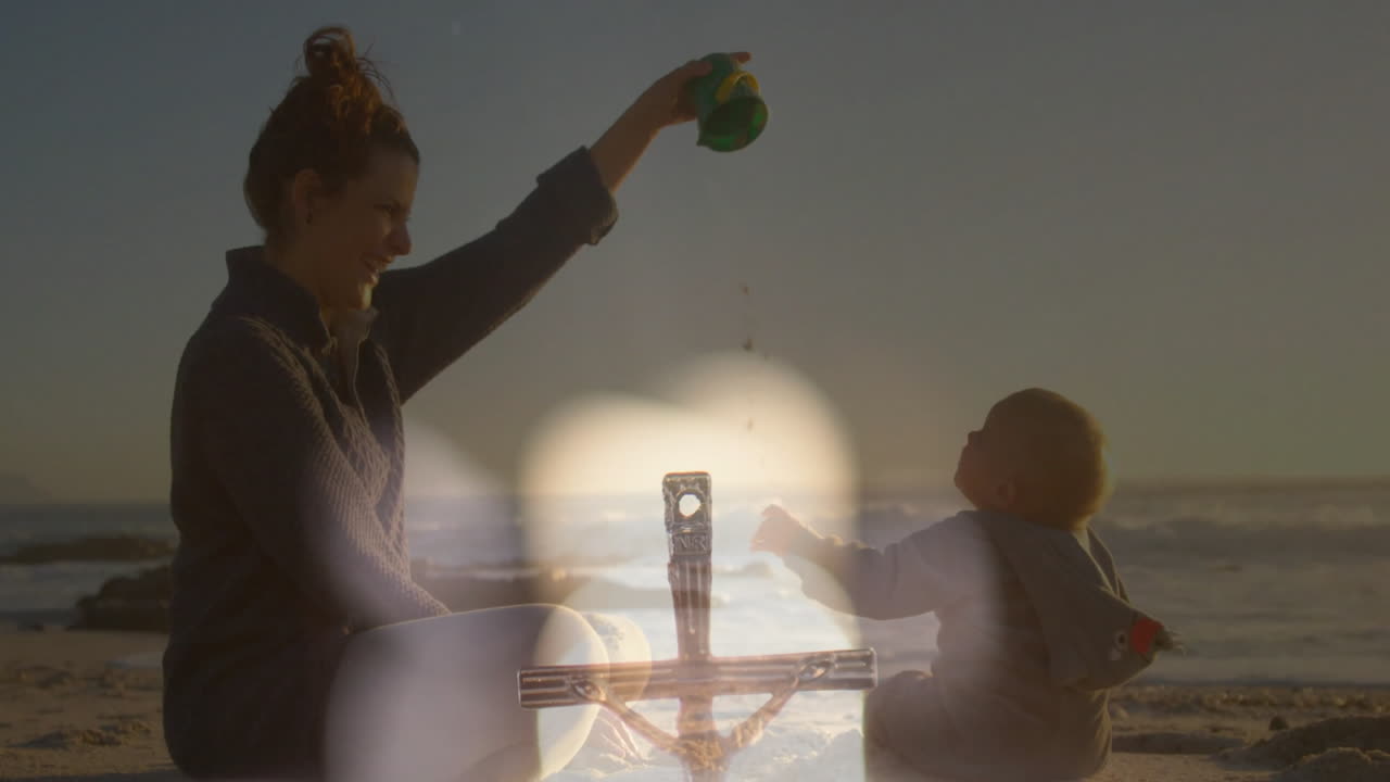Playing on beach, mother and child with animation of abstract light overlay
