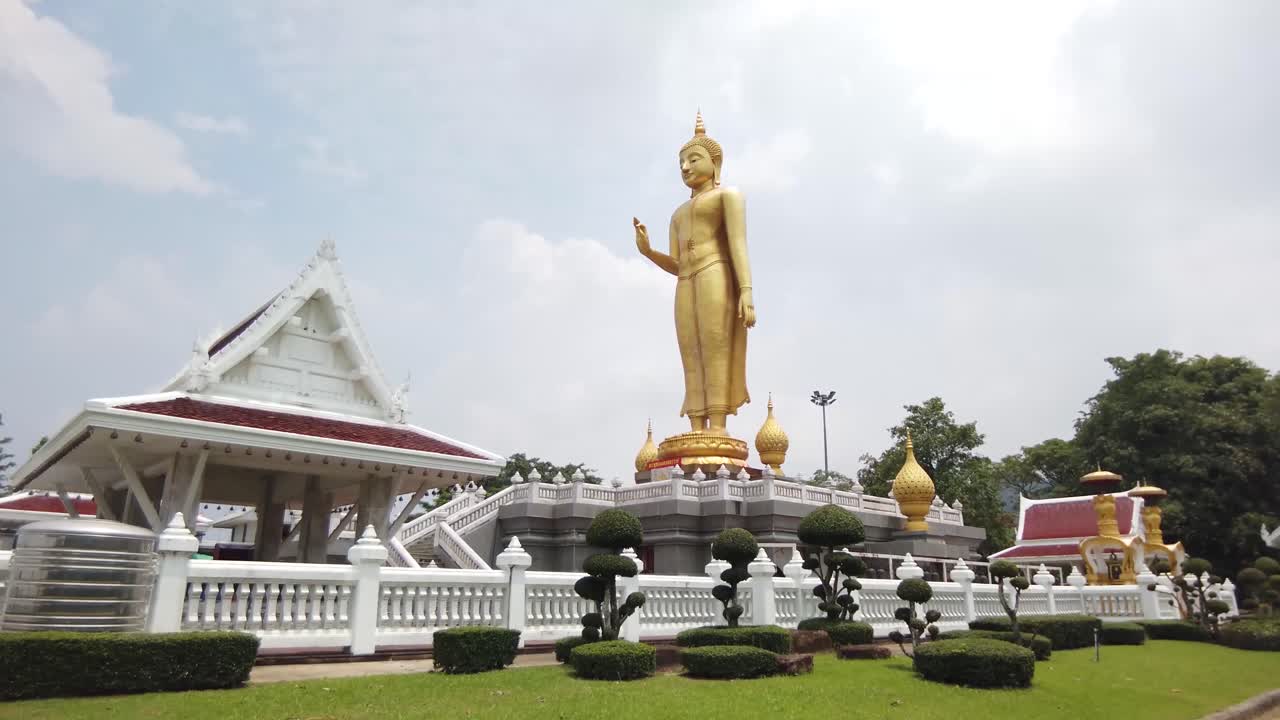 estatua gigante de oro de buda de pie, al aire libre