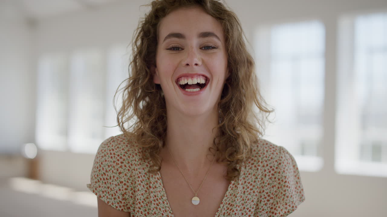 retrato de una joven feliz estudiante riendo mirando a la cámara disfrutando de un estilo de vida independiente hermosa mujer relajada despreocupada en el fondo del apartamento