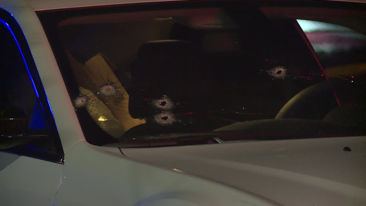 밤에 자동차 앞 유리에 갱단의 총알 구멍