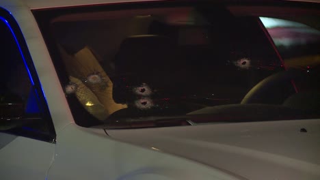 GANG-BULLET-HOLES-IN-CAR-WINDSHIELD-AT-NIGHT