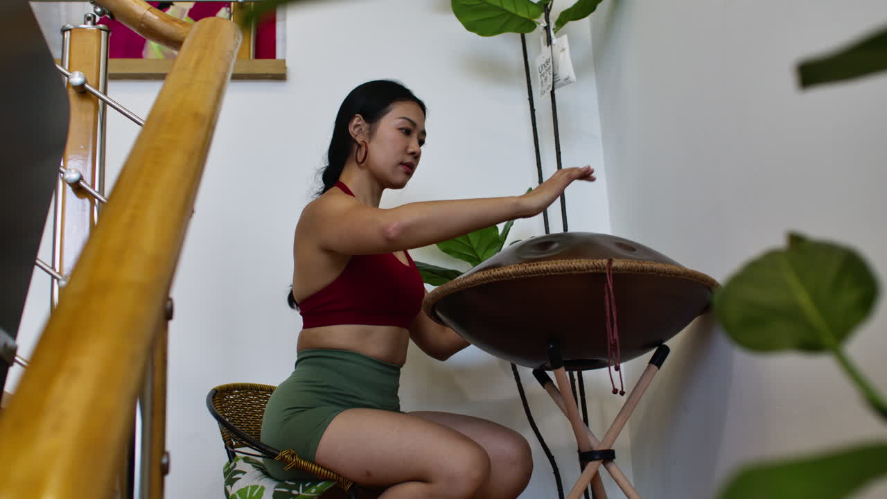 Woman playing handpan indoors