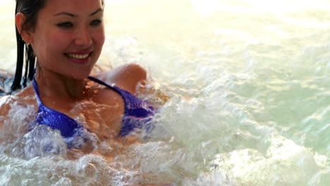 Happy-brunette-relaxing-in-the-jacuzzi