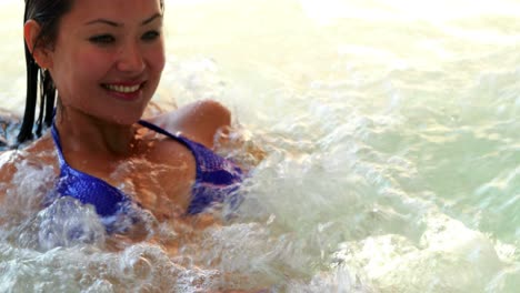bruneta feliz relajándose en el jacuzzi