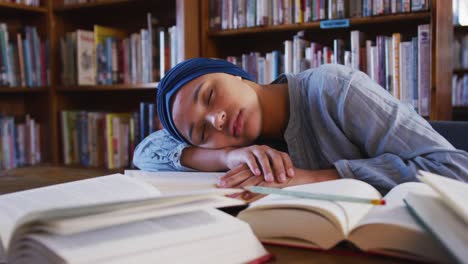 girl in hijab sleeping in the library