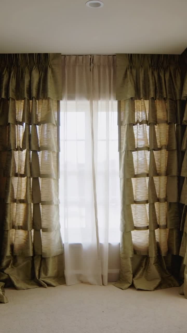 Vídeo vertical: Cortinas transparentes e laterais se movendo com a brisa pela janela em um quarto acarpetado