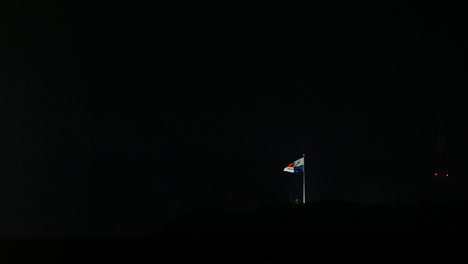 lit up panama flag streaming in night sky on cerro ancón