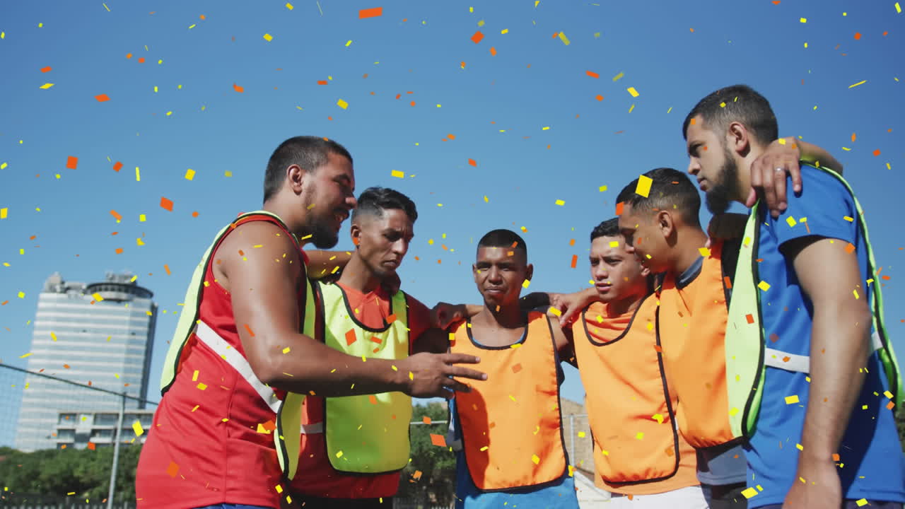 confeti colorido cayendo contra un equipo de jugadores de fútbol masculino discutiendo la estrategia del equipo