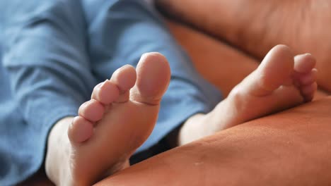 relajándose con los pies descalzos en un sofá