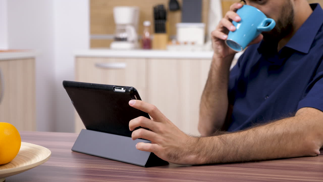 hombre usando tableta en la cocina