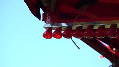 4k red lights blinking under a circus striped tent at fun fair