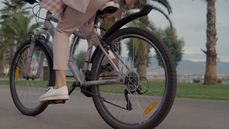 donna in bicicletta in un parco