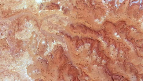 drone looks down at the martian-like terrain of the badlands of monument valley