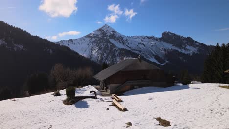 refugio de montaña en un día de primavera temprano con grandes montañas en el fondo