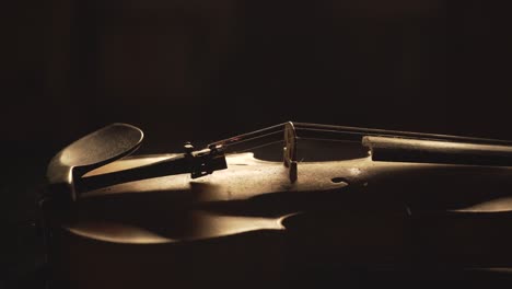 close up of old violin, dramatic light changes over the instrument , classical symphony music video footage