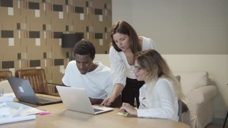 group of diverse coworkers sitting and standing at table